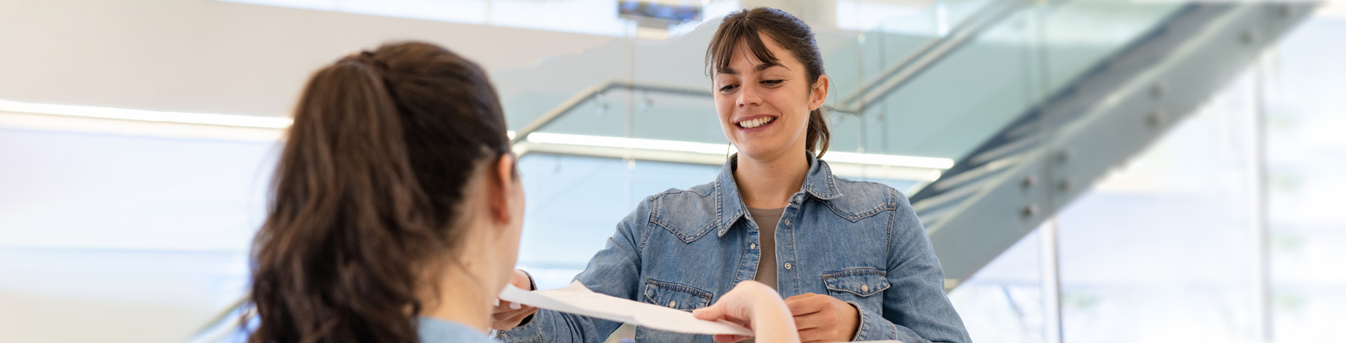 Finish Line Friday banner image of a woman smiling and receiving a piece of paper from another woman