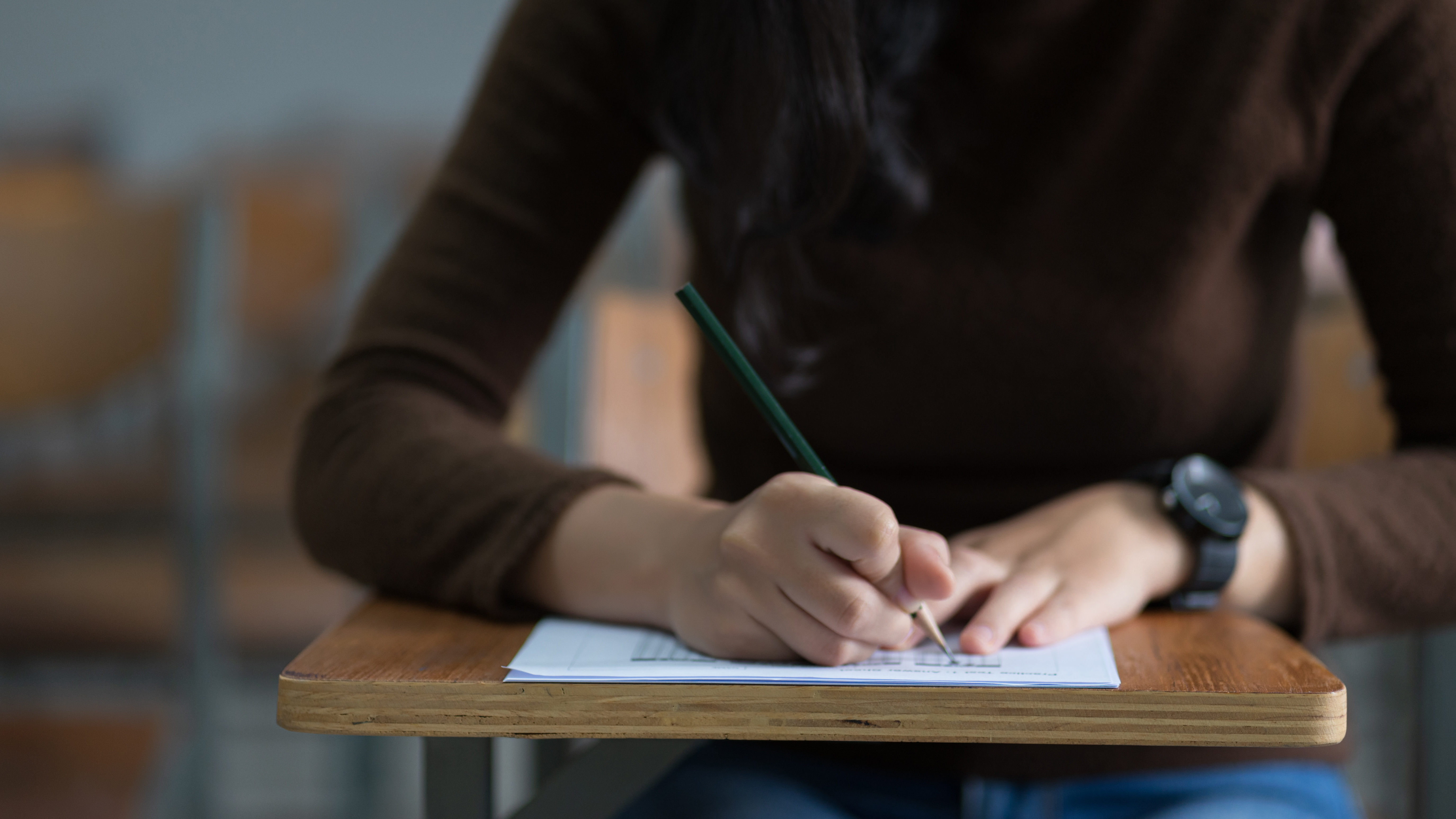 A student fills out a Scantron while taking a test.