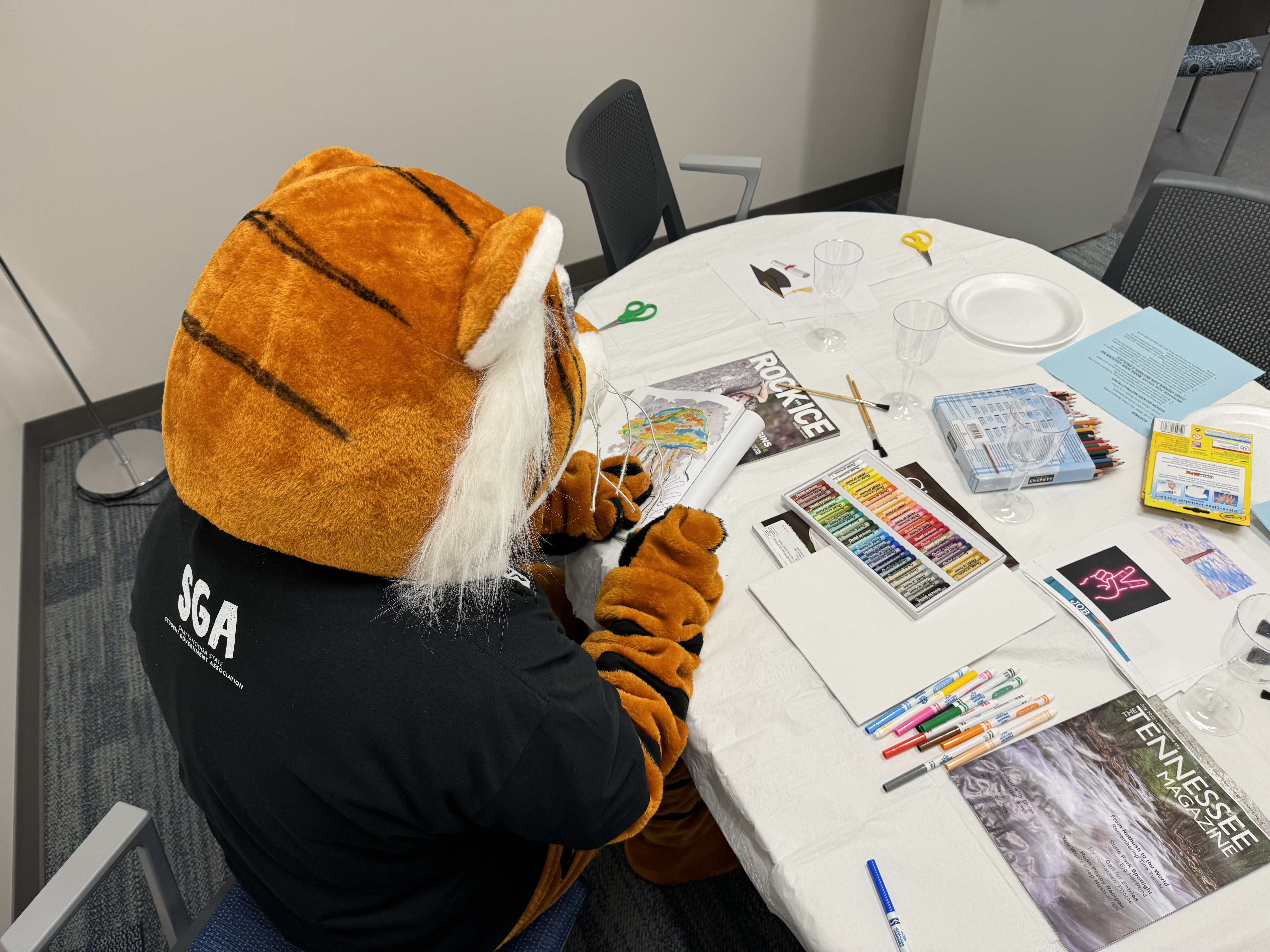 ChattState's Tiger mascot paints a vision board.