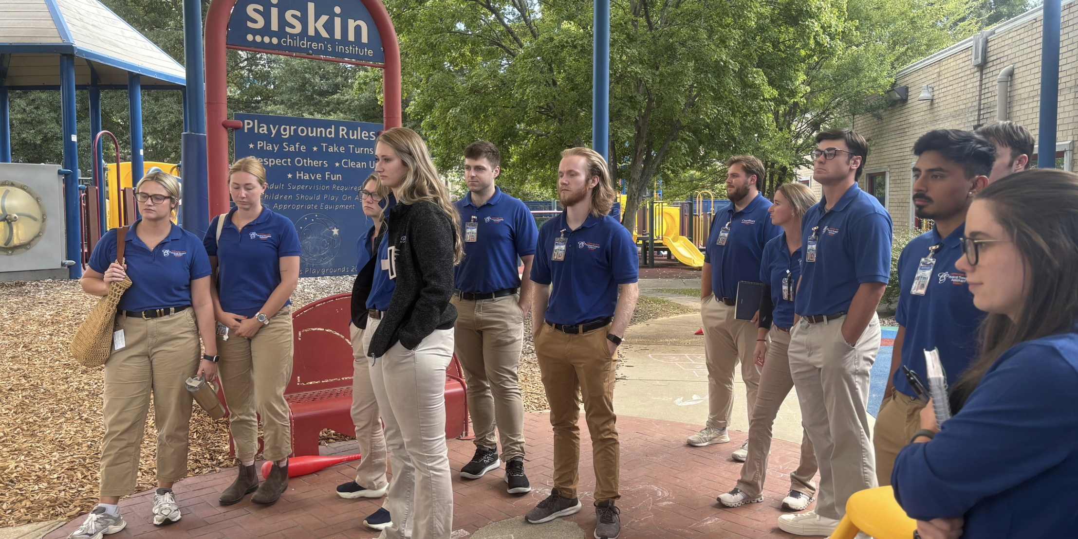 a group of PTA students learning pediatrics on a playground