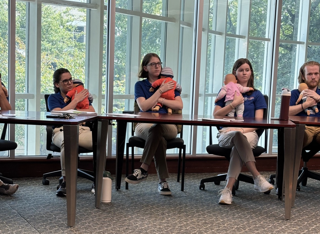 physical therapist students holding baby dolls as part of pediatric care training