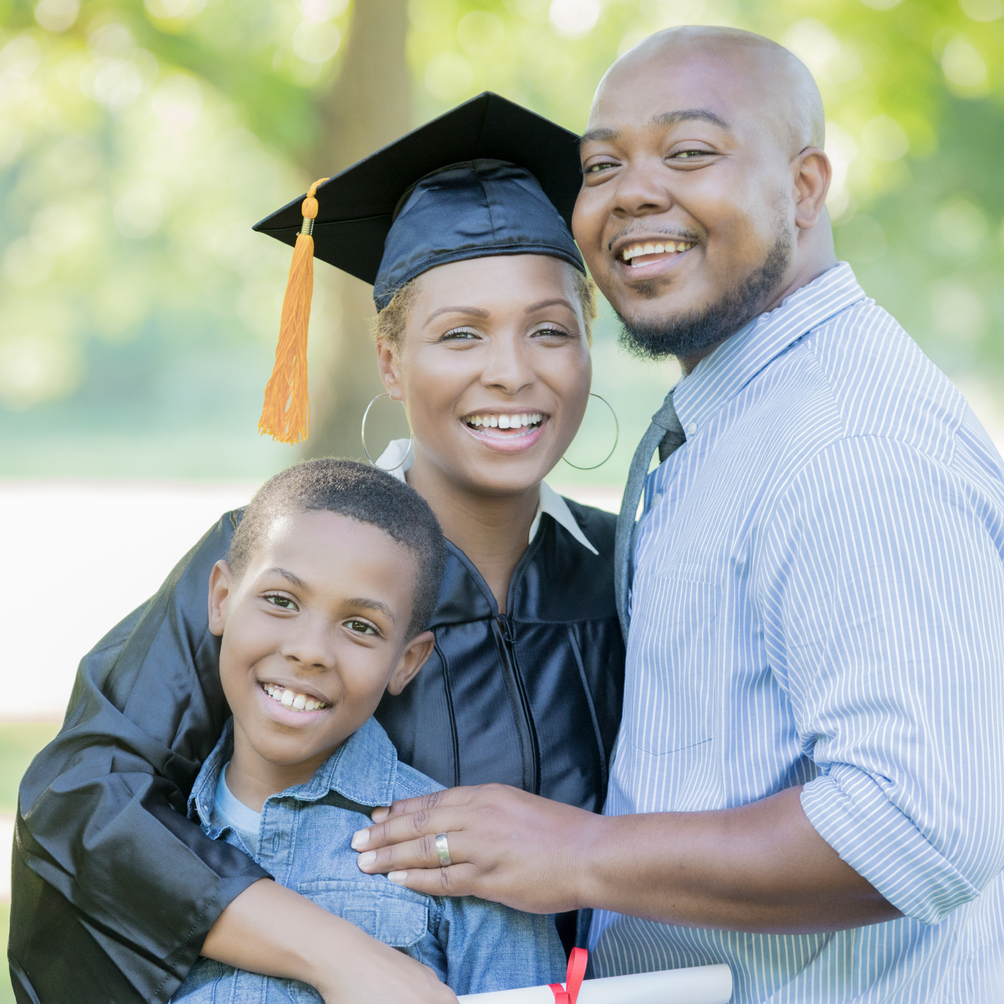 3 people at a graduation–2 adults and 1 child