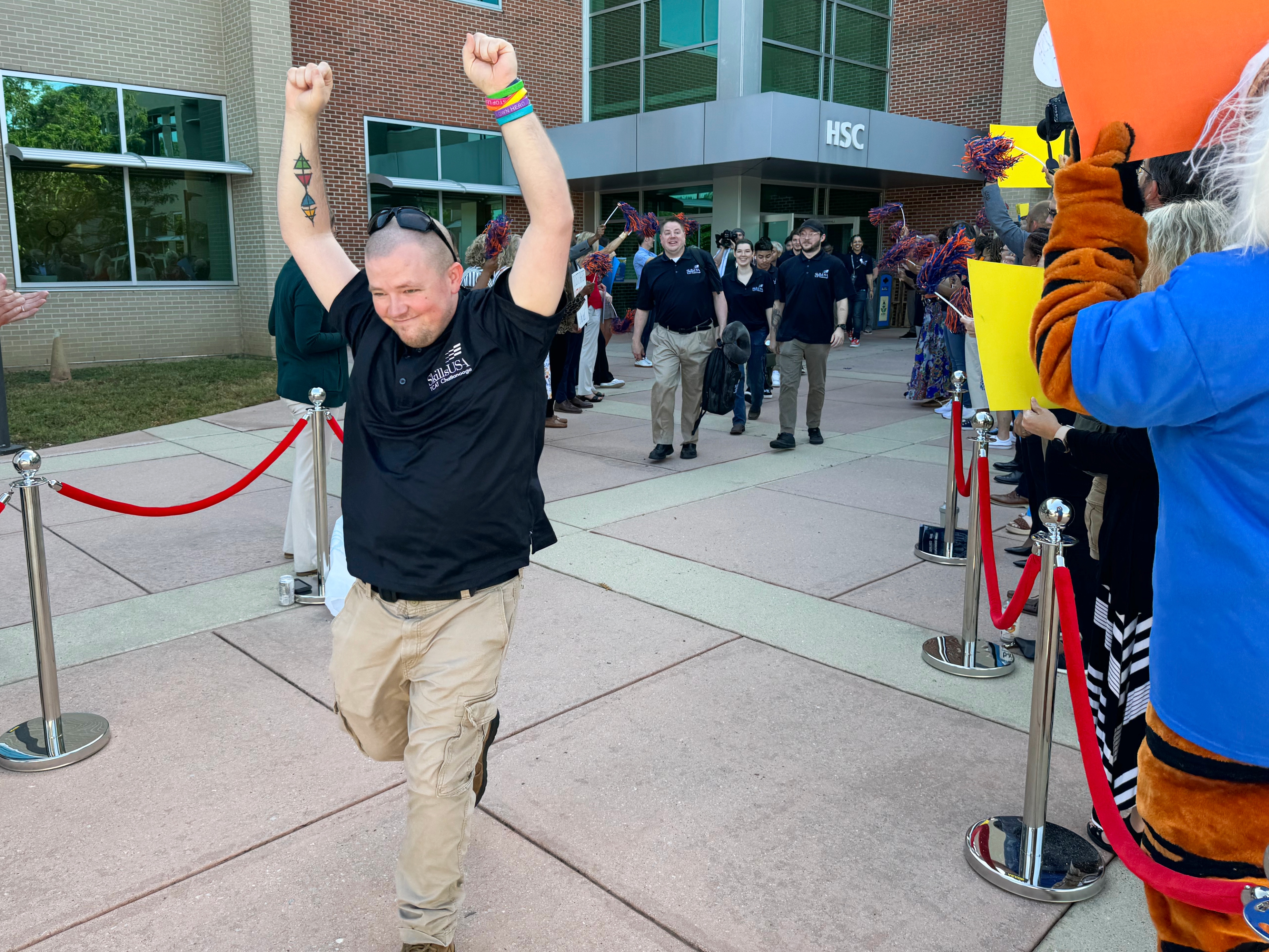 ChattState student John Jordan raises his hands in the air before boarding a bus to SkillsUSA's national competition in Atlanta.