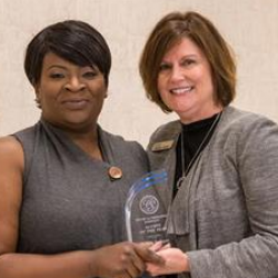 PTA program director Caroline Rogers (right) presents the PTA Alumni of the Year award to 2006 graduate and inventor of CPR Life Wrap to Felicia Jackson (left).