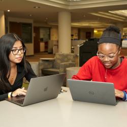 Two students look at their computers in ChattState's library.