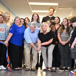 A group of students, faculty, and staff gather in a hallway at ChattState