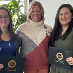 3 women two are holding certificates