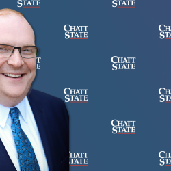Brad McCormick in front of blue background with ChattState Logo