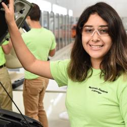 student with hand on car hood