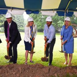 men & women with shovels breking ground