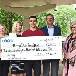 group of people holding a large check for presentation