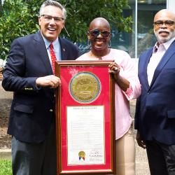 2 men and a woman with an award 