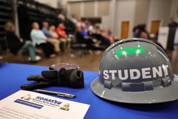 A Student helmet on a desk next to Komatsu forms.