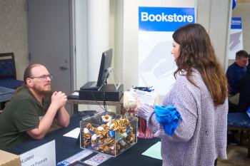 A ChattState student talks to a bookstore worker during the Fall 2023 grad finale.