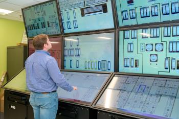 A man looks at a simulated nuclear control room.