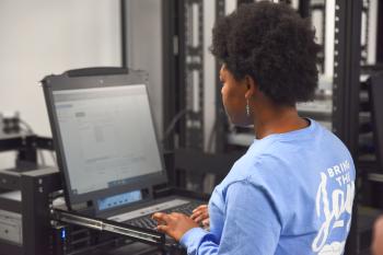 A woman in a blue shirt types on a computer. A woman in a blue shirt types on a computer.