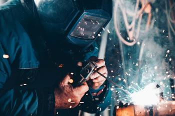 A person is seen welding. Image credit: Christopher Burns, via Usplash.