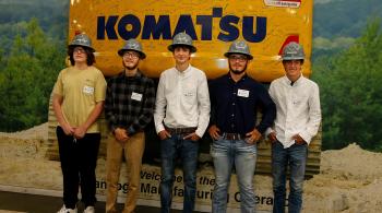 students wearing hard hats in front of Komatsu sign