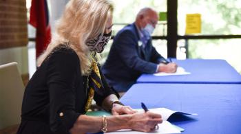 woman and man at table signing agreement