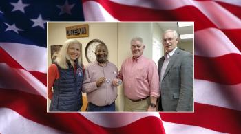 woman and three men against a flag background