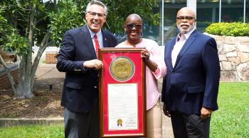 2 men and a woman with an award 