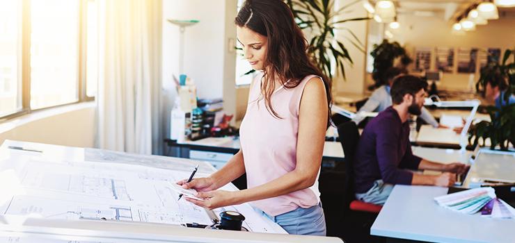 woman lookover blueprints near the window