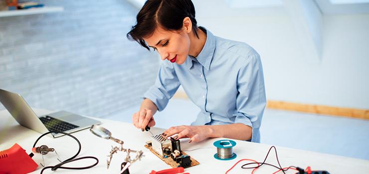 Engineer assembling electronic parts and components at her desk