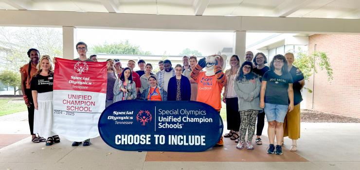 A group of students and ChattState's tiger mascot hold a sign that reads "Special Olympics Unified Champion Schools. Choose to include." 