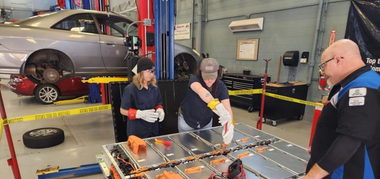 two female EV Engineering Tech students working in a garage
