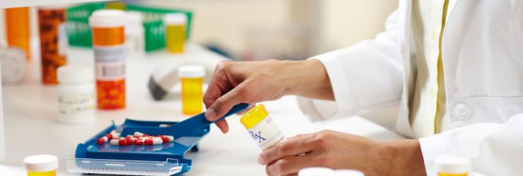pharmacy tech measuring pills at pharmacy